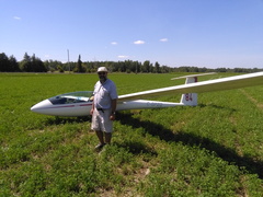 A Man With His Glider in an Alfalfa Field
